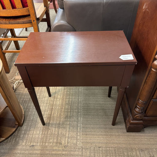 Wooden side table in a room with furniture and carpet