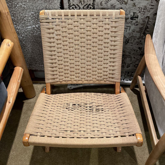 A low-profile wooden accent chair with a tan woven cord seat and backrest, featuring a minimalist slatted frame.