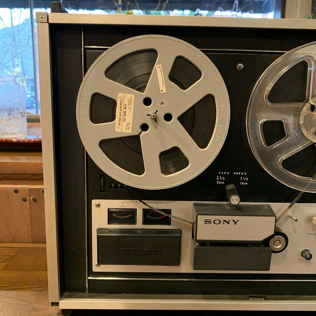 Vintage Sony reel-to-reel tape recorder with reels and control panel.