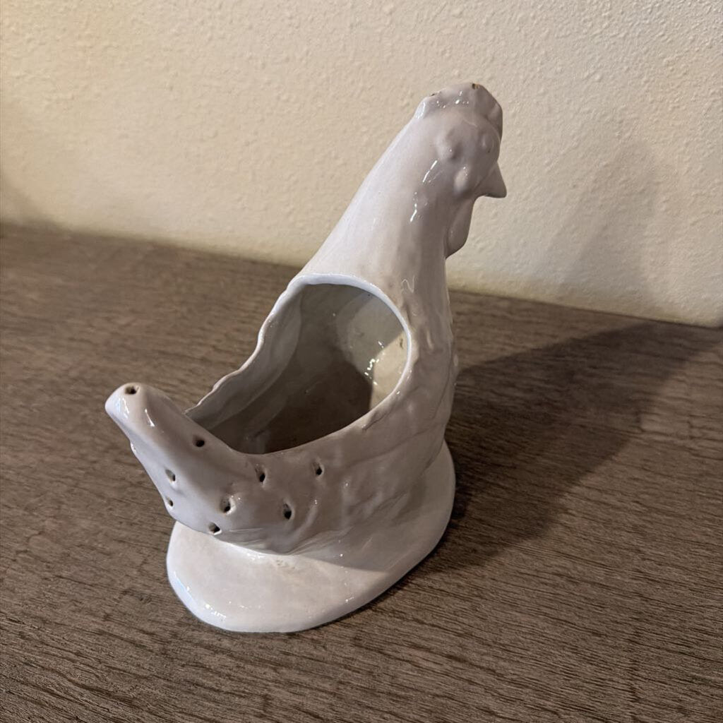 The piece is sculpted as a chicken, with a distinctive off-white glaze that highlights the feathered surface and the bird's expressive features.