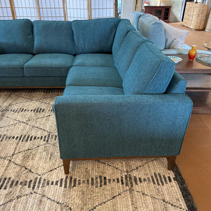 Blue sectional sofa in a living room setting with a patterned rug.