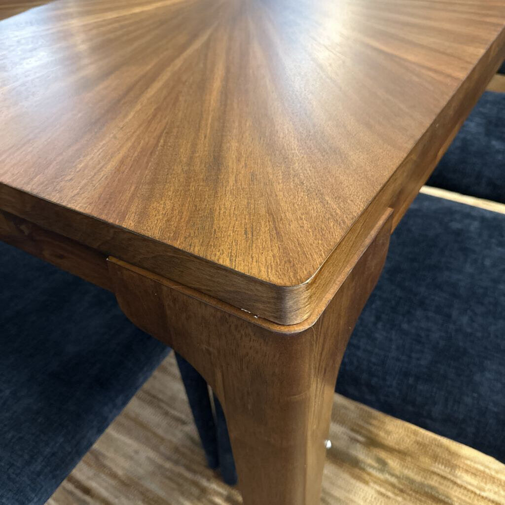 Close-up of a wooden table with a blue chair underneath