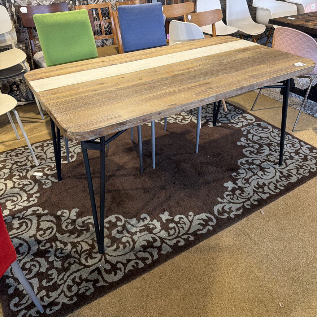 Wooden dining table with metal legs on a patterned rug