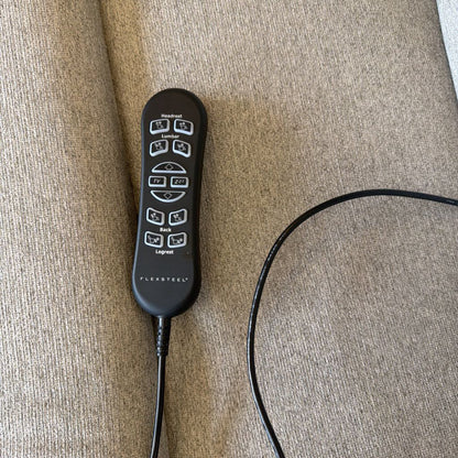 Black electronic device with buttons on a beige surface