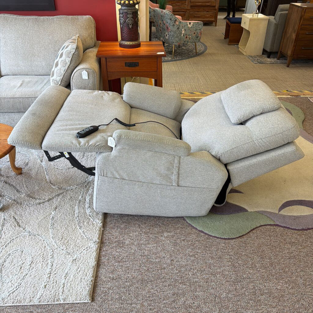 Gray recliner sofa in a room with a red wall and other furniture.