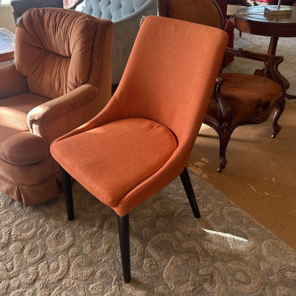 Orange chair in a room with other furniture