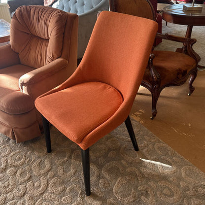 Orange chair in a room with other furniture