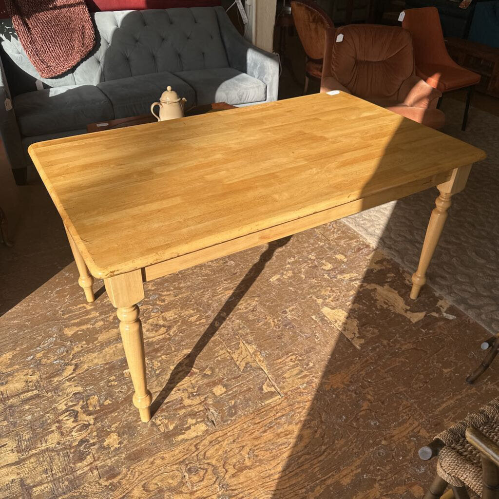 Wooden table on a wooden floor with furniture in the background