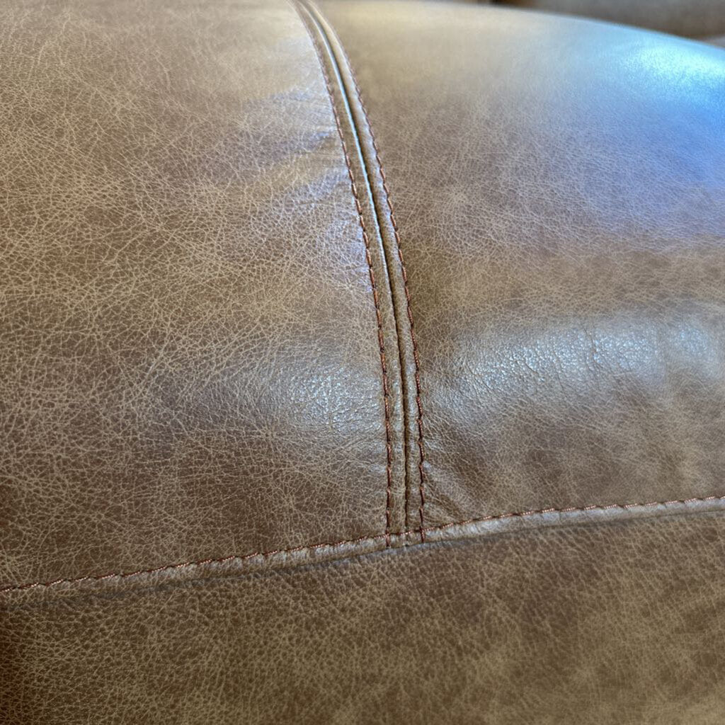 Close-up of brown leather surface with visible stitching