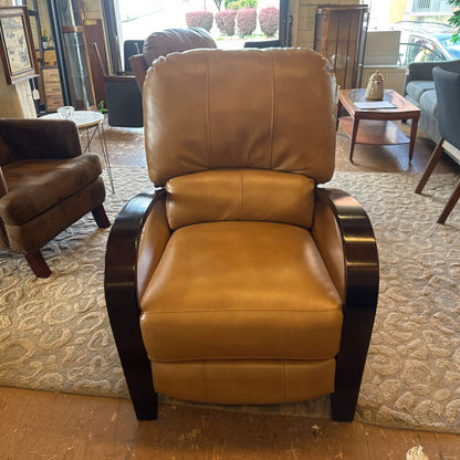 Brown leather recliner chair in a showroom setting with other furniture.