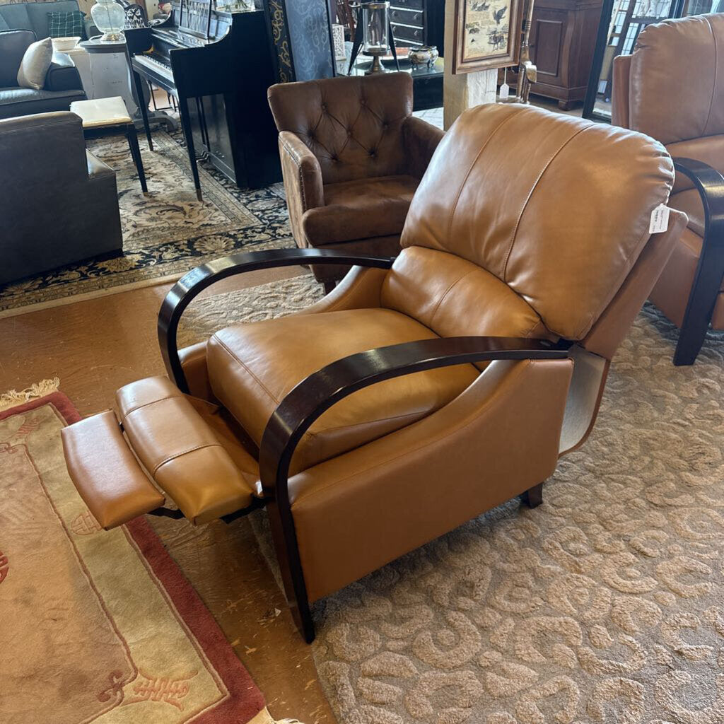 Brown leather recliner chair in a showroom setting with other furniture.