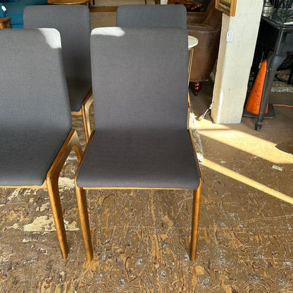 Gray chairs with wooden legs on a worn wooden floor