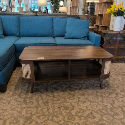 Blue sectional sofa with a wooden coffee table in a room setting.