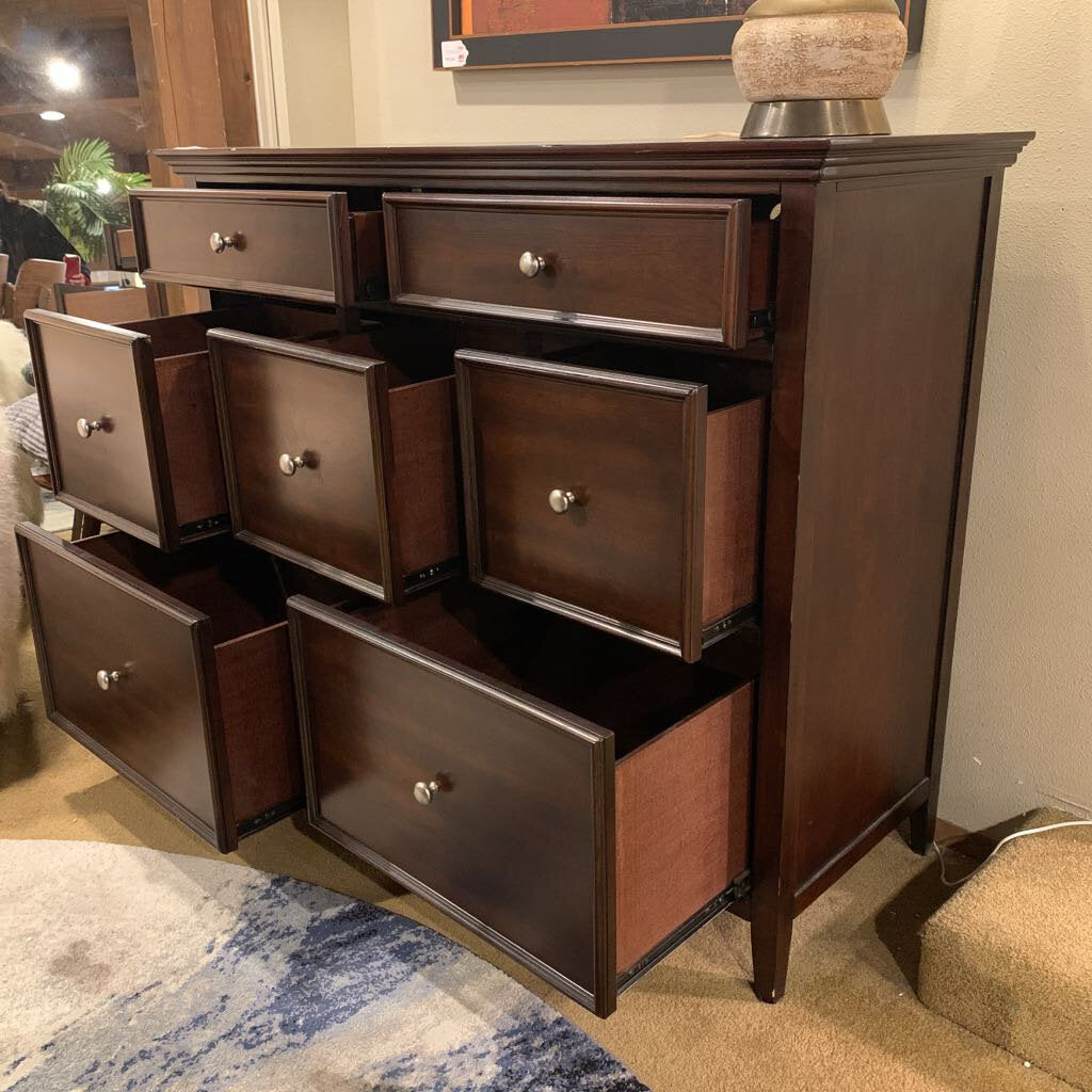 Wooden dresser with multiple drawers in a room setting