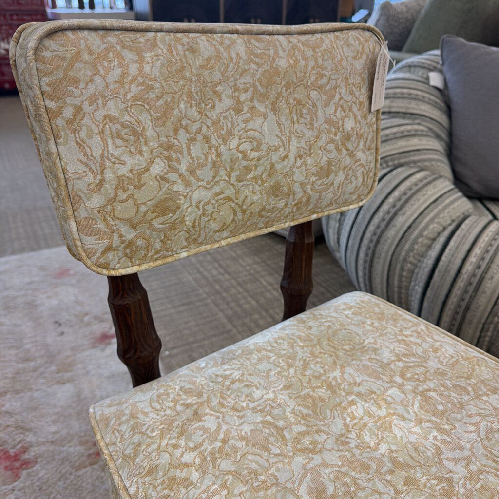 Two patterned chairs with wooden legs in a living room setting.