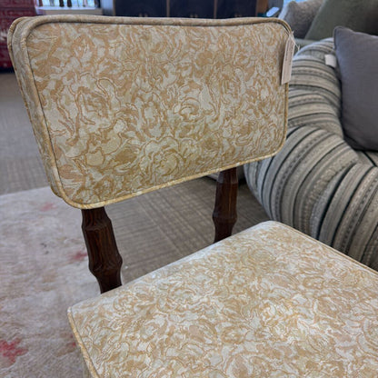 Two patterned chairs with wooden legs in a living room setting.