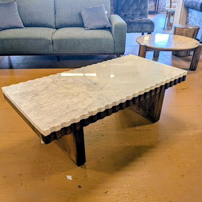 Coffee table with marble top and wooden base in a living room setting