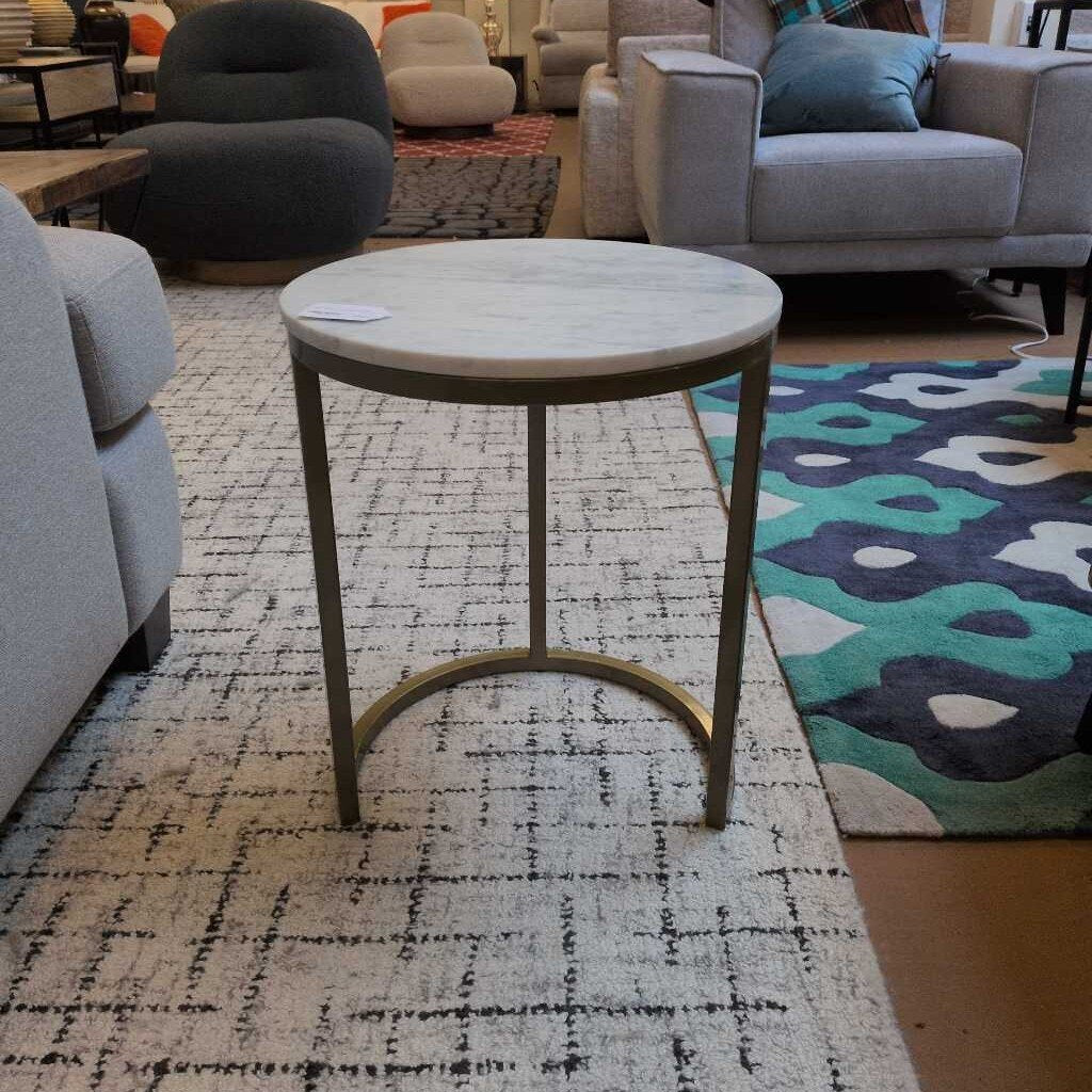 Round side table in a living room setting with furniture and rug.