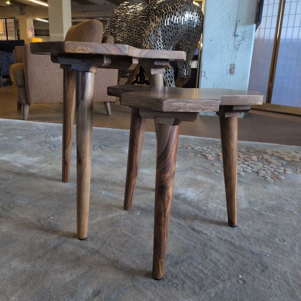 Two wooden tables with twisted legs on a textured floor.