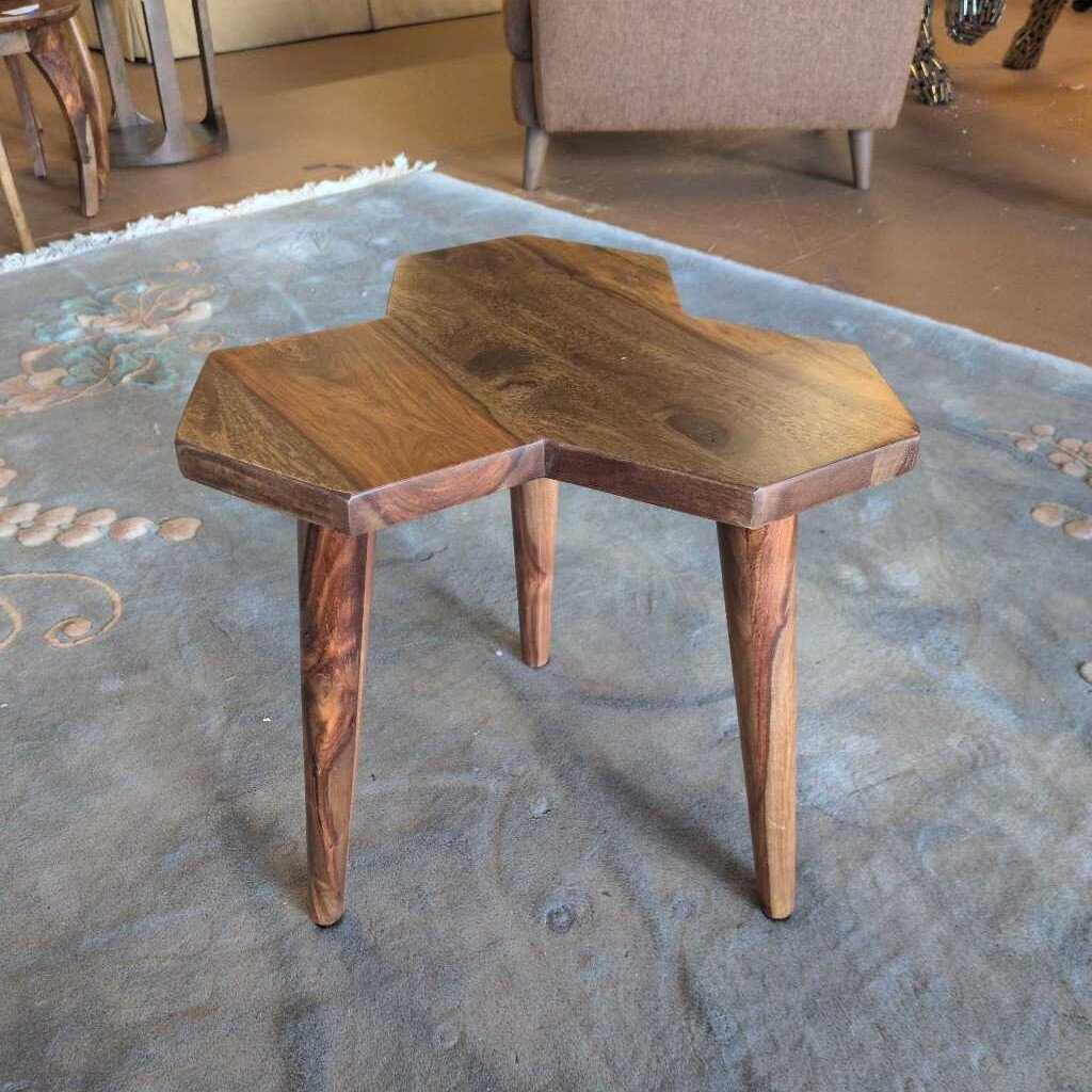 Two wooden stools on a textured rug with a blurred background