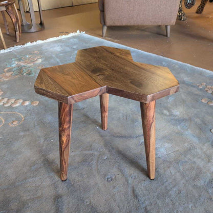 Two wooden stools on a textured rug with a blurred background