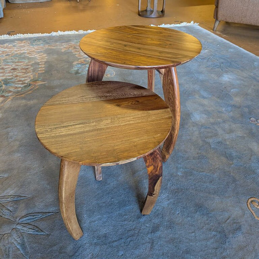 Wooden side table with a rug and furniture in the background