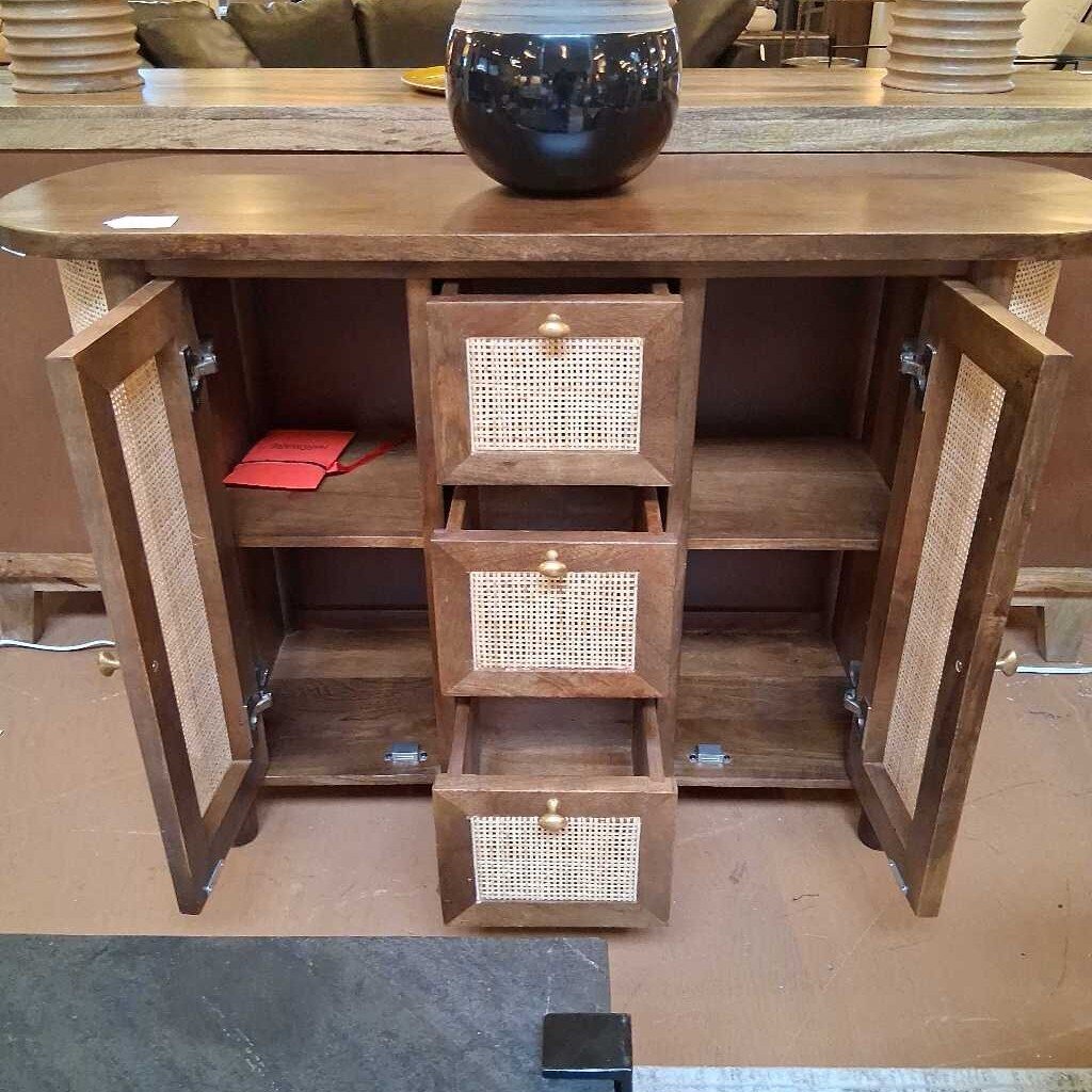 Wooden sideboard with open doors and drawers in a showroom setting