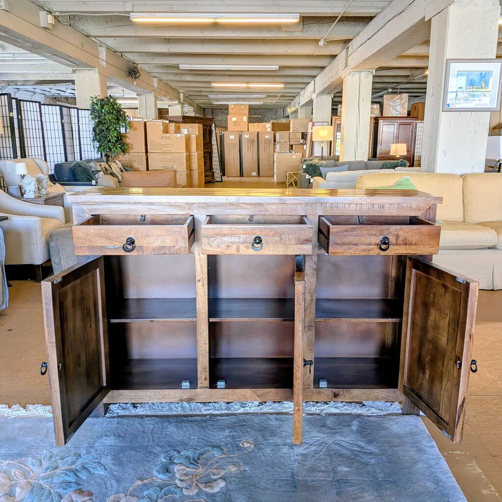 Wooden sideboard with open doors in a furniture store setting
