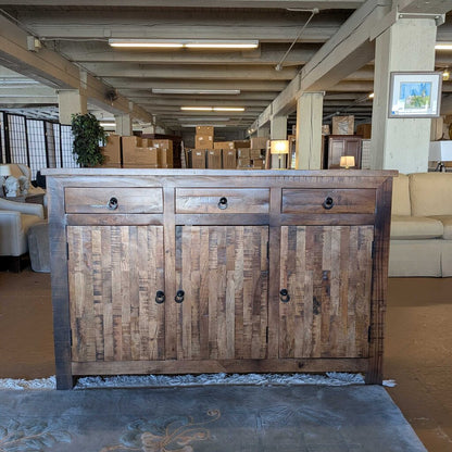Wooden cabinet with three drawers and doors in a showroom setting