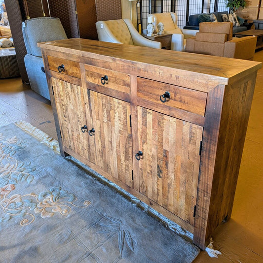 Wooden sideboard in a living room setting with furniture and decor.