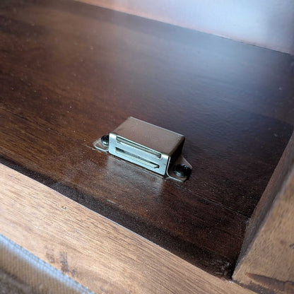 Metal cabinet hinge on a wooden surface