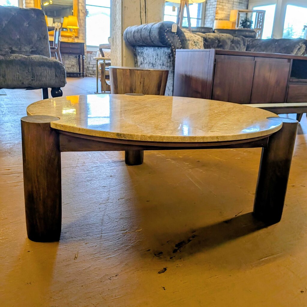 Round wooden coffee table in a room with furniture and decor