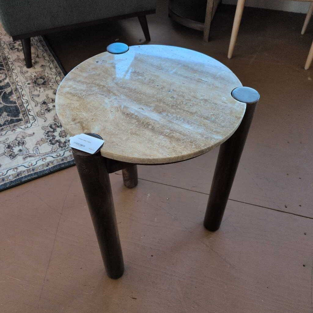 Small round table with marble top and wooden legs on a floor.