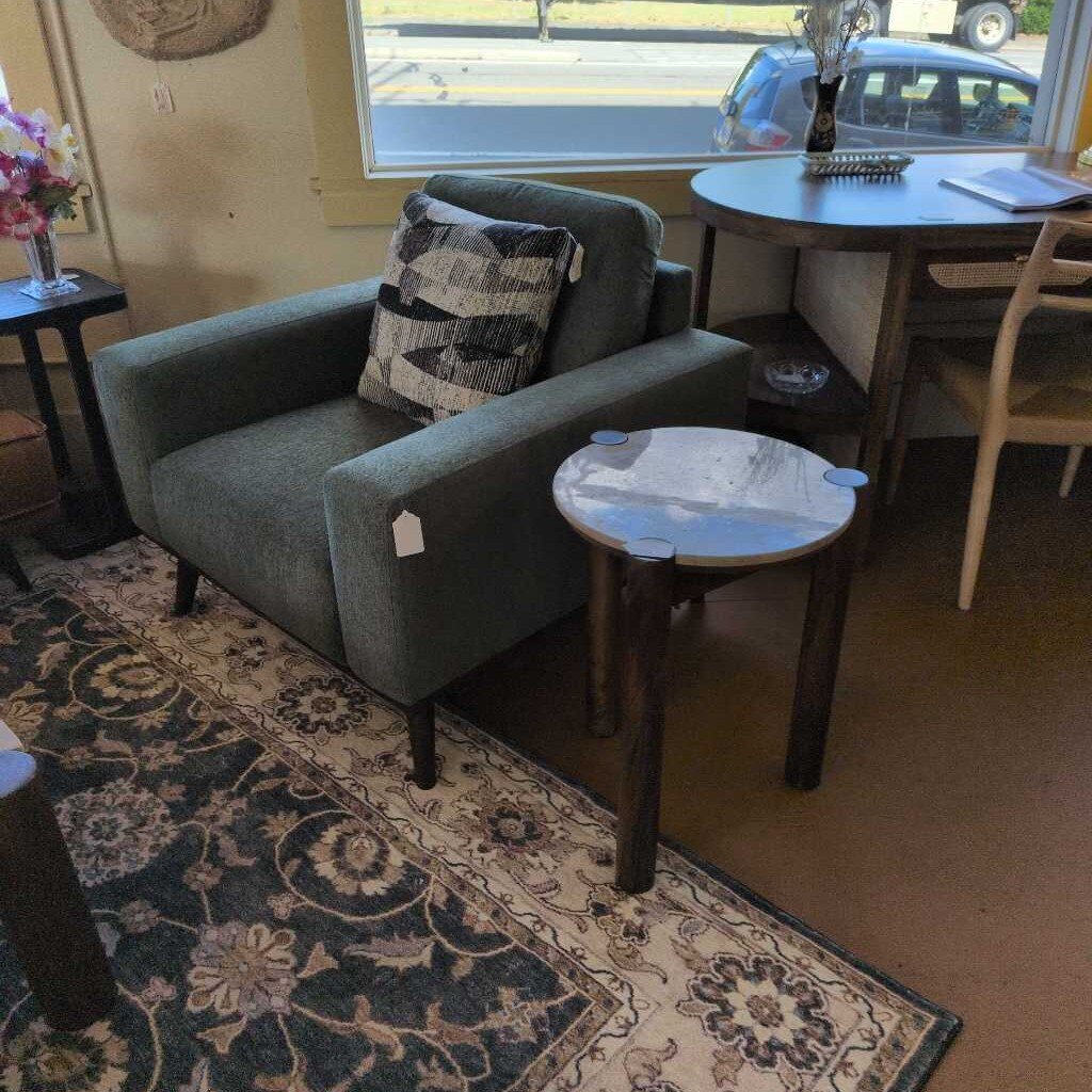 Gray sofa with a patterned pillow in a room with a dining table and chairs.