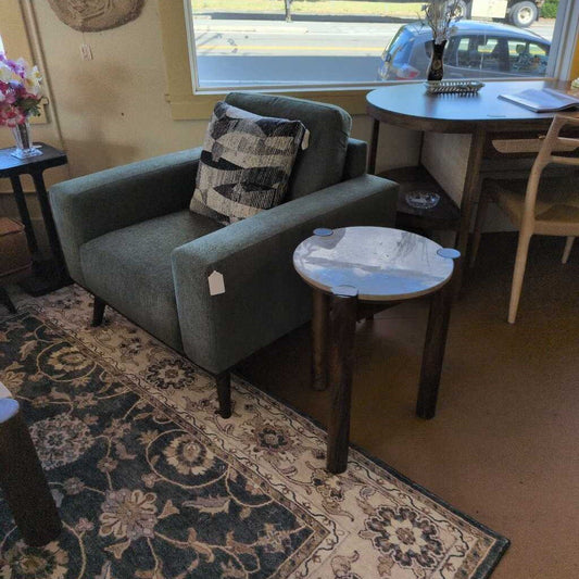 Gray sofa with a patterned pillow in a room with a dining table and chairs.