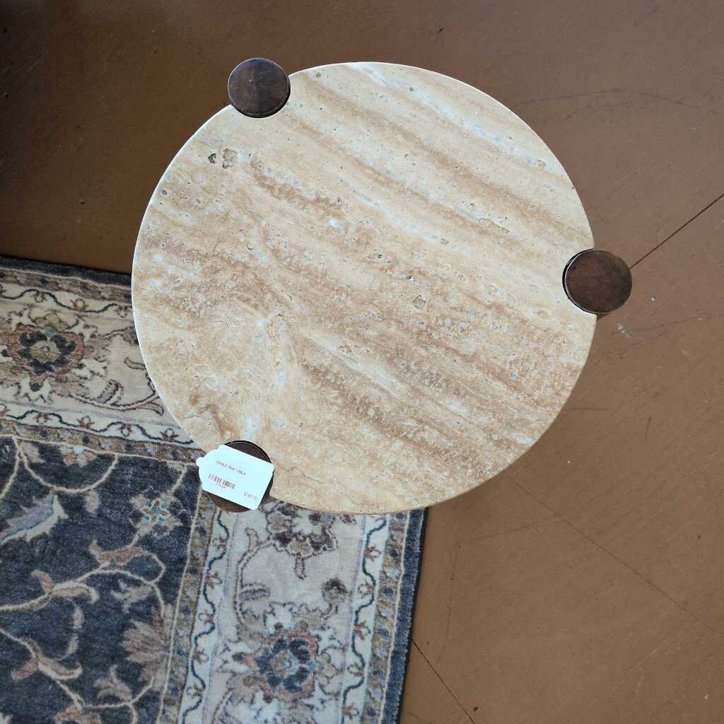 Round marble slab with three wooden knobs on a cardboard surface