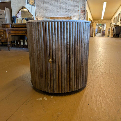 Wooden barrel with metal accents on a wooden floor in a warehouse setting