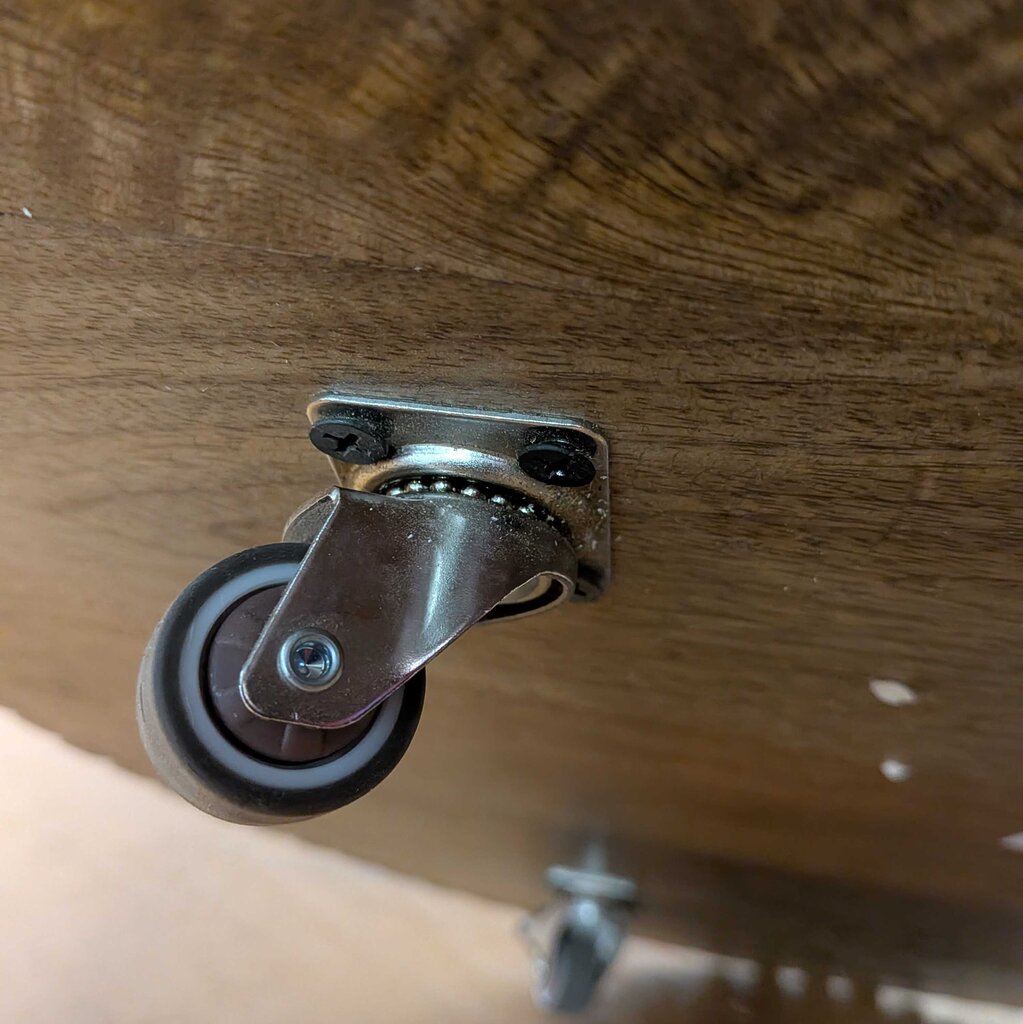 Caster wheel attached to a wooden surface