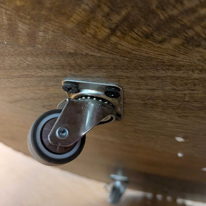 Caster wheel attached to a wooden surface