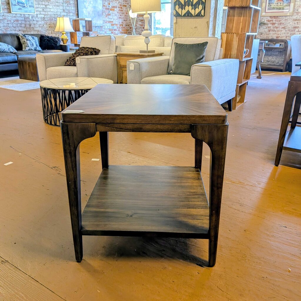 Wooden side table in a furniture store with sofas and decor in the background