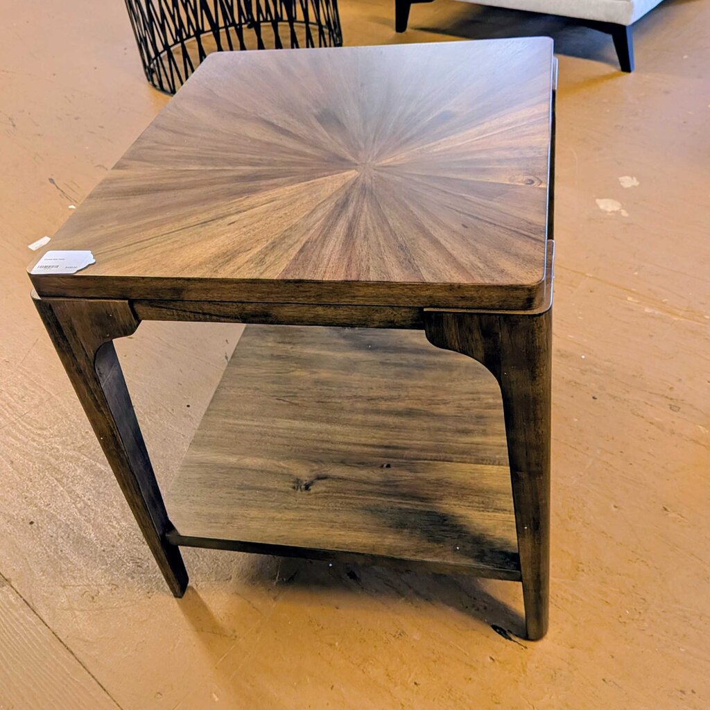 Wooden side table with a starburst pattern on a wooden floor