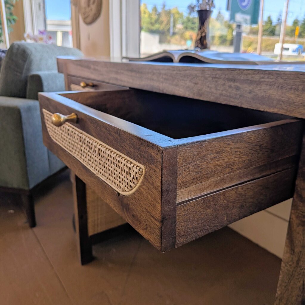 Wooden drawer with a gold handle on a wooden table.