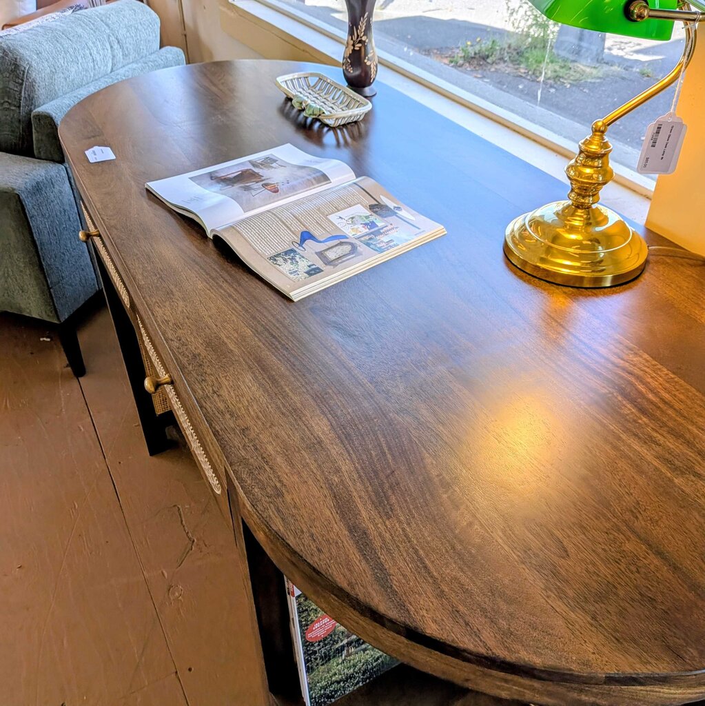 Wooden dining table with a lamp and open book in a home setting