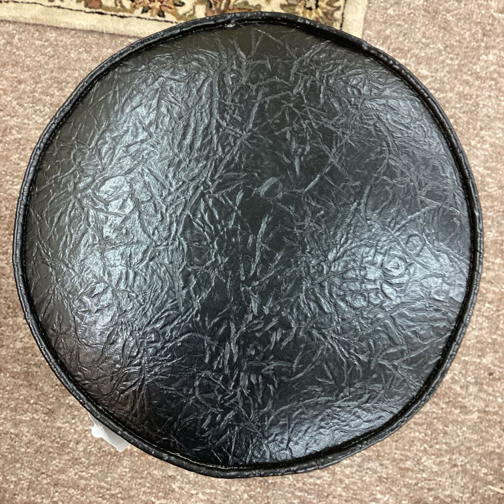 Black textured round object on a brown surface