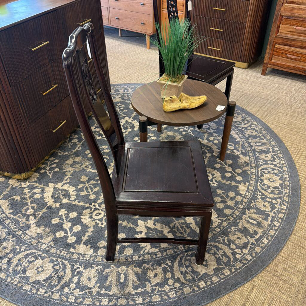 Wooden chair on a patterned rug with furniture in the background