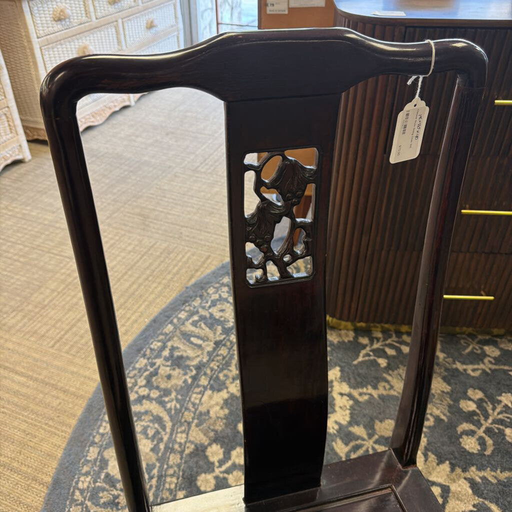 Dark wooden chair with decorative backrest in a room setting