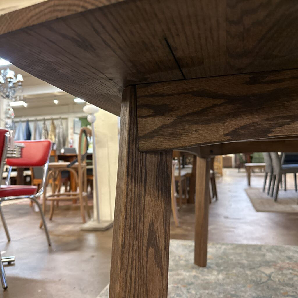 Close-up of a wooden chair leg with a blurred background of a store interior.