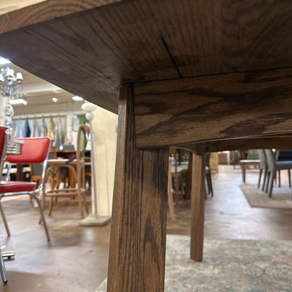 Close-up of a wooden chair leg with a blurred background of a store interior.