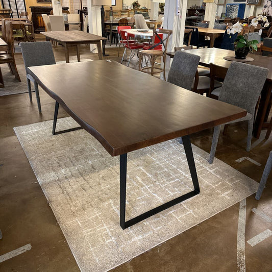 Dining table with black metal legs in a showroom setting