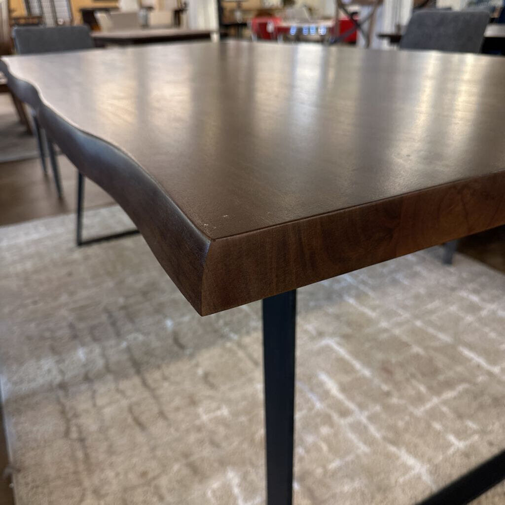 Wooden table with black legs in a room setting